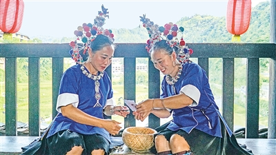     程陽橋上，侗族婦女在展示制作侗族刺繡產(chǎn)品。繡品圖案精美、色彩艷麗，成為當?shù)靥厣a(chǎn)業(yè)。